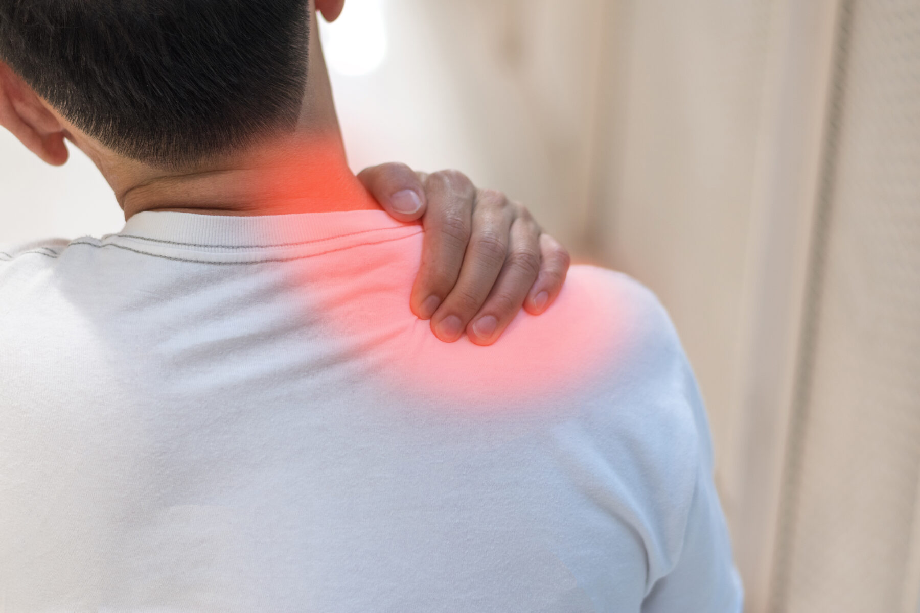 person holding the base of the neck and top of the shoulder with the painful area highlighted in red
